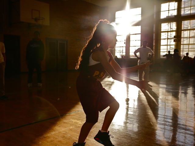 <p>A young girl dribbles the ball in preparation for a P.S. 67 basketball game.</p>
