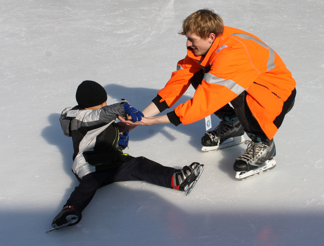 <p>An ice guard helps a fallen skater.</p>

