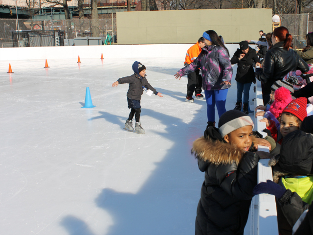 <p>An ice guard helps a new skater.</p>
