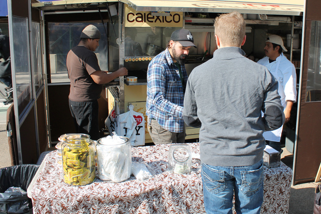 <p>Calexico line cook Anthony Suarez, second from left in black hat, seen here serving a customer in Worth Square Feb. 15, 2013, said he would welcome a market in the plaza. "It's actually a lot of fun for us," Suarez said.</p>
