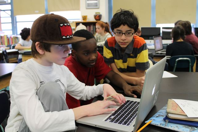<p>Middle school boys work together on a science project on a laptop.</p>
