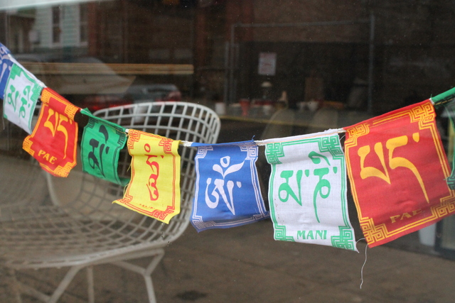 <p>Tibetan prayer flags adorn the door of Goodies, a new juice bar and cafe behind Good Yoga in Bed-Stuy.</p>
