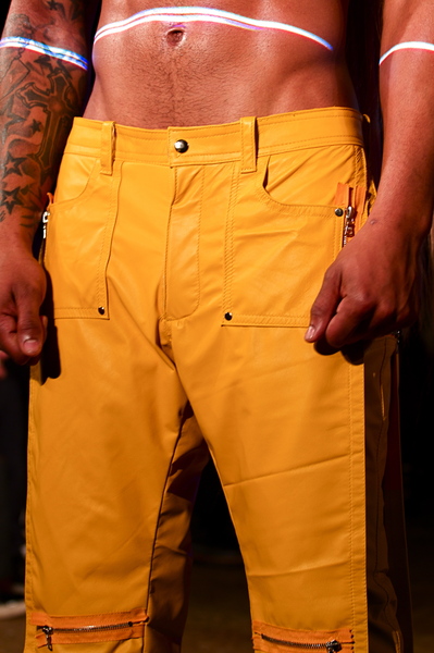 <p>Detail of yellow leather knee length pants with utility details</p>
