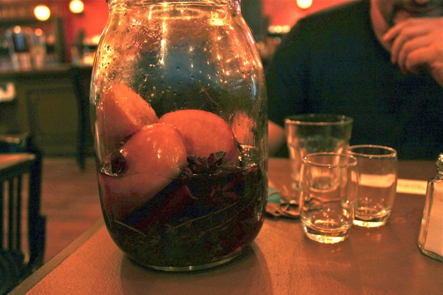 <p>On the back wall, next to the open kitchen, the shelves are lined with dozens of jars filled with Arnon Magel's very own liquor infusions.</p>

