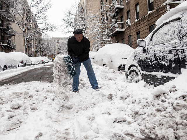 <p>Marcos Herbert, 51, digs out the snow from his Toyota Previa on Bennett Ave., in Washington Heights on Feb. 9, 2013.</p>

