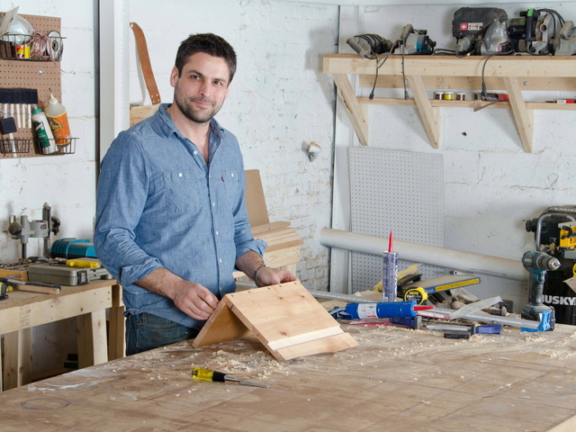 <p>Mark Jupiter stands near a table he made from an old Singer sewing machine and wood from a redwood tree.</p>

