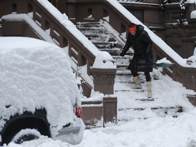 <p>A woman shovels the stairs at a house on West 70th Street on Feb. 9, 2013.</p>
