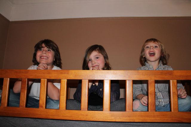 <p>The Treitler children, Jake, 7, Ella, 5, and Ezra, 4, sit atop the bunk bed in their bedroom.&nbsp;</p>

