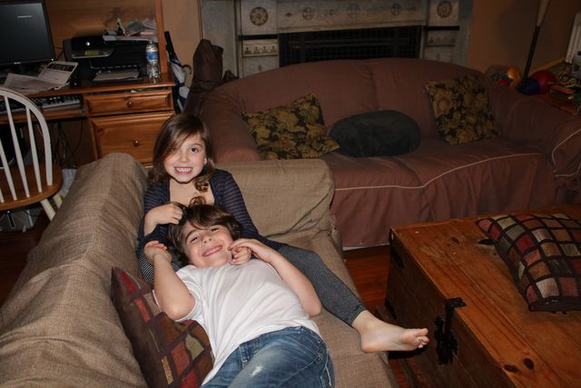 <p>Jake and Ella Treitler&nbsp;sit together on the couch in the living room, which used to double as their brother's bedroom at night.</p>
