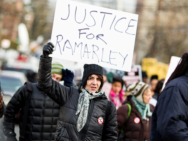 <p>A woman holds up a protest sign at the one-year anniversary of Ramarley Graham in the Bronx on Feb. 2, 2013.</p>
