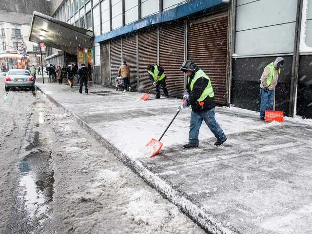 <p>Transit workers clear snow from the sidewalk outside the George Washington Bus Terminal in Washington Heights on Feb. 8, 2013.</p>
