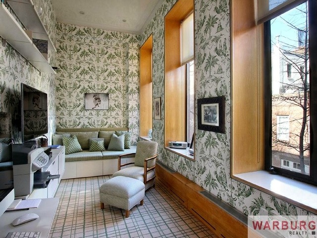 <p>The floor-through co-op's second bedroom is a cozy space with oversized windows.&nbsp;</p>
