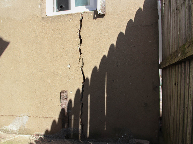 <p>The cracked concrete on the back of 776 New Dorp Lane faces the backyard of Jessica Abouabdallah's home on Neptune Avenue. Abouadallah, 28, said she's worried a storm could destroy the house and damage her property. She said she's called the city several times to complain, March 5, 2013.</p>
