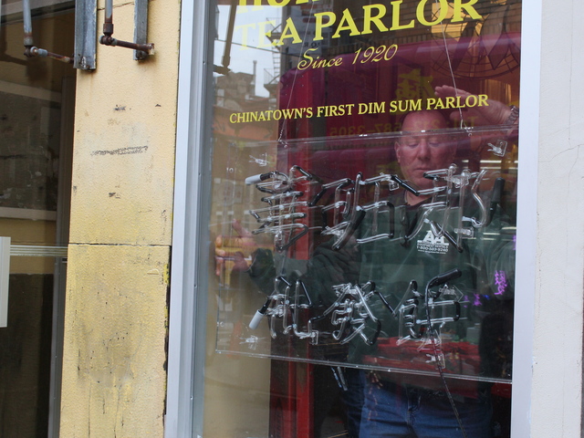 <p>A film crew member affixes a neon sign inside Nom Wah Tea Parlor ahead of filming for "The Amazing Spider-Man 2."</p>
