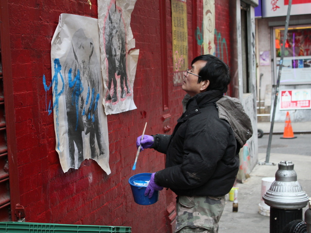 <p>A film crew member paints signs on Doyers Street ahead of filming for "The Amazing Spider-Man 2."</p>
