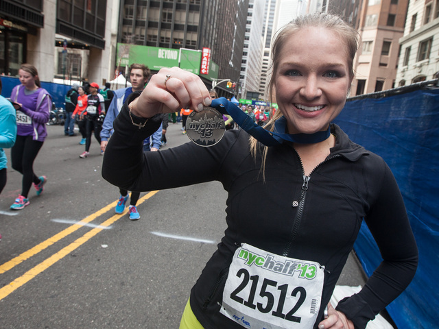 <p>Carey Piascik, 26, holds up her medal after completing the annual NYC Half marathon on Mar. 17, 2013.</p>
