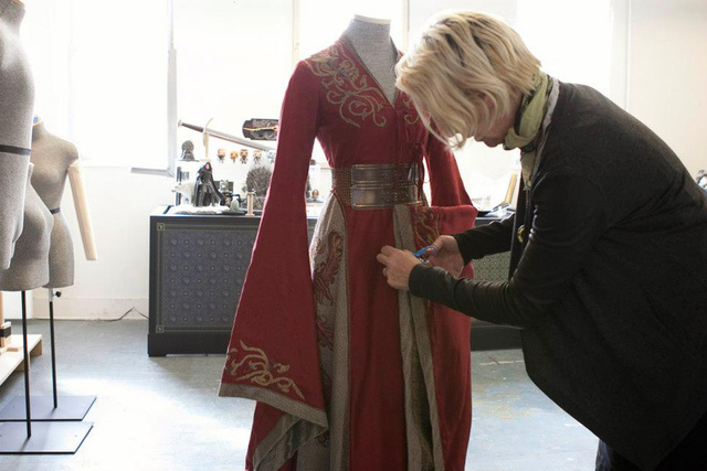 <p>A costume designer puts the finishing touches on an outfit for the 'Game of Thrones' exhibition taking place in Midtown Thursday, March 28, 2013.</p>
