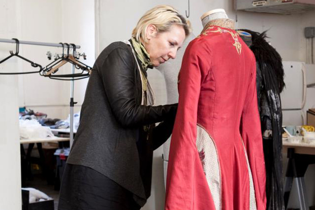 <p>A costume designer puts the finishing touches on an outfit for the 'Game of Thrones' exhibition taking place in Midtown Thursday, March 28, 2013.</p>
