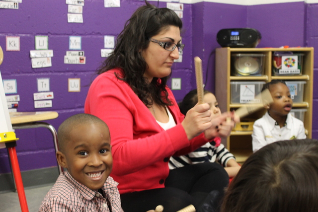 <p>Jenna Delia teaches her students about rhythm using drumsticks.</p>
