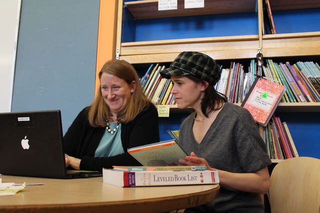 <p>Parents Maura Duff and Maydelle Liss examine the computerized book lending system in the new book room.&nbsp;</p>

