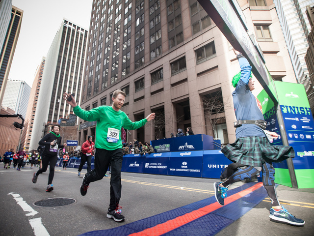 <p>A runner crosses the finishing line of the annual NYC Half marathon at the South Street Seaport on Mar. 17, 2013.</p>
