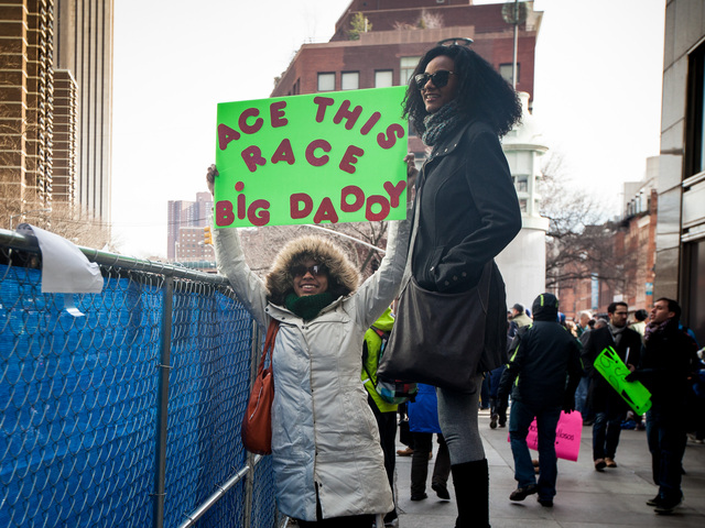 <p>Spectators hold up signs of encouragement for runners at the annual NYC Half marathon at the South Street Seaport on Mar. 17 , 2013.</p>
