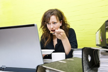 A woman eating lunch at her work desk. It's an unhealthy habit, medical professionals say. For those who can't avoid it, however, it's important to still take a break and walk around, they added.