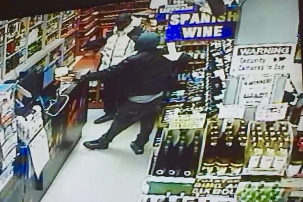 Police released a surveillance picture of three suspects wanted for stealing bottles of liquor in Forest Hills.