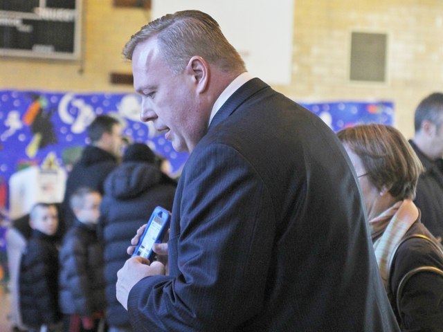 <p>City Councilman Dan Halloran helps a voter find her election district at P.S. 184 in Whitestone on Nov. 6.</p>
