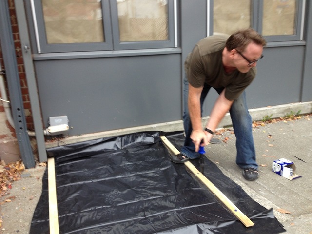 <p>Architect Jim Cameron, 42, used plastic tarp, wood planks and a fastener to seal the cellar hatch outside his building on Van Brunt Street on October 28, 2012.</p>
