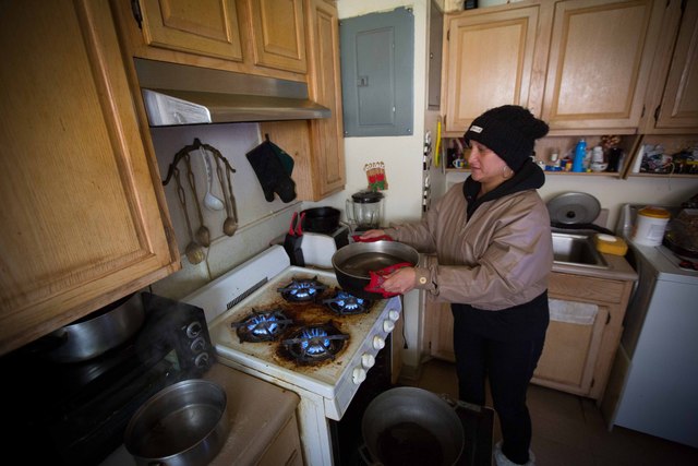 <p>Kisha James, 38, put water on the stove as a way to heat up her three-bedroom apartment by Beach 64th Street in the Rockaways on Nov. 5, 2012 after Hurricane Sandy.</p>
