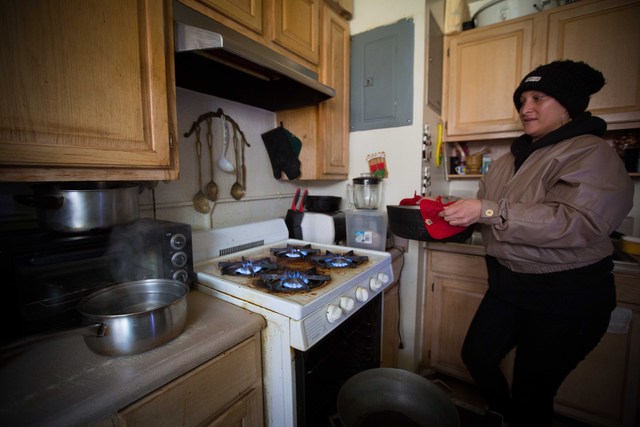 <p>Kisha James, 38, put water on the stove as a way to heat up her three-bedroom apartment by Beach 64th Street in the Rockaways on Nov. 5, 2012 after Hurricane Sandy.</p>
