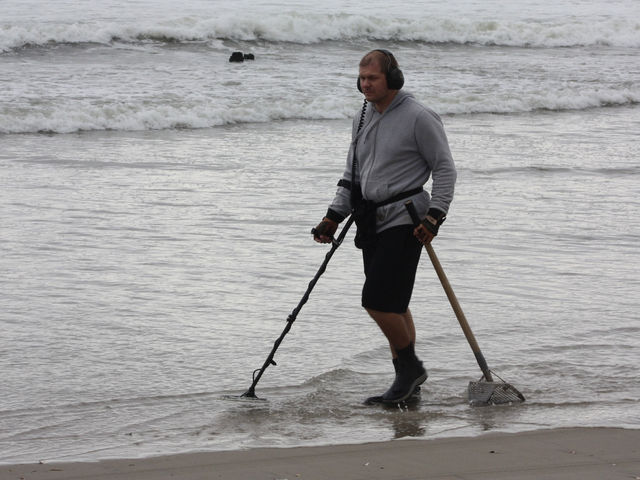 <p>A man uses a metal detector on the beach at Breezy Point, Oct. 28, 2012.</p>
