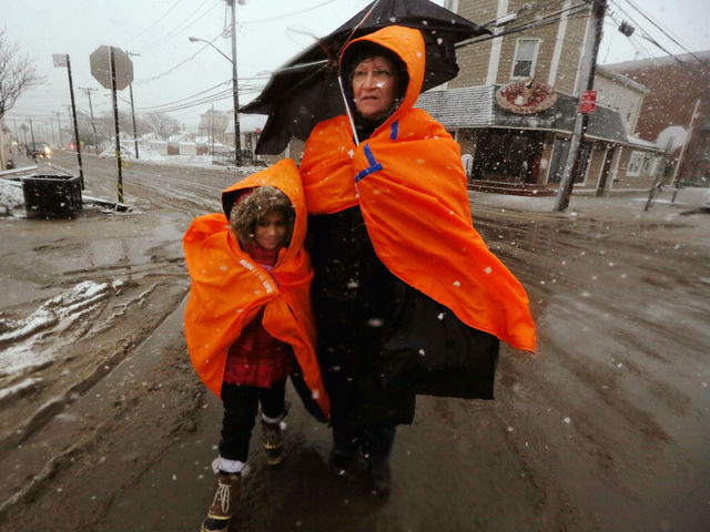 <p>Fatima Quentiro walks with her granddaughter Galalea Castro through the snow to a bus stop to take a bus to Quenitro&rsquo;s home after Castro&rsquo;s home was damaged by flooding as a Nor&rsquo;Easter approaches in the Rockaway neighborhood on November 7, 2012 in the Queens borough of New York City. The two are wearing jackets donated by the NYC Marathon. The Rockaway Peninsula was especially hard hit by Superstorm Sandy and some are evacuating ahead of the coming storm.</p>
