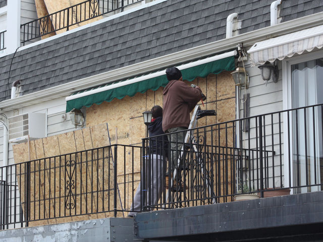 <p>Men board up a home in the Rockaways in anticipation of Hurricane Sandy, Oct. 28, 2012.</p>

