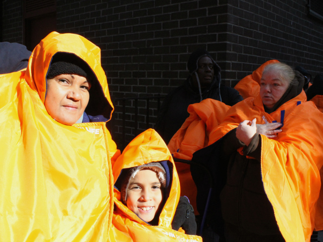 <p>Gladys Torres and her grandson, AJ, 7, tried to keep warm as they waited in line Monday.</p>
