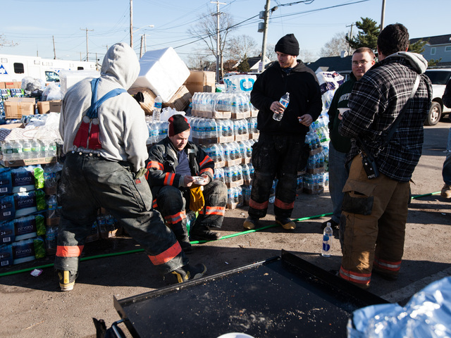 <p>Volunteer firefighters of Rockaway Point Volunteer Fire Dept. and local residents take a break while distributing supplies to the local community in Rockaway Point Nov. 5th, 2012.</p>
