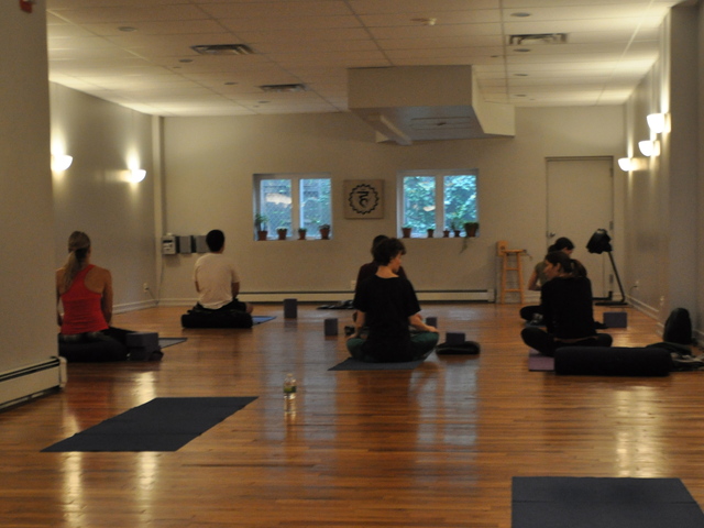 <p>Students settled on their mats in Abhyasa Yoga Studio.</p>
