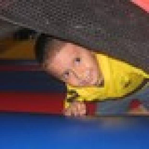 Alexis Espinoza, 3, pokes out from the bounce house.