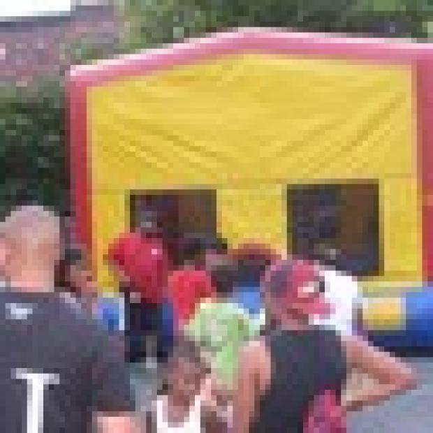 Bare-footed kids wait for their turn to jump in the bounce house, the evening's most popular attraction, by far.