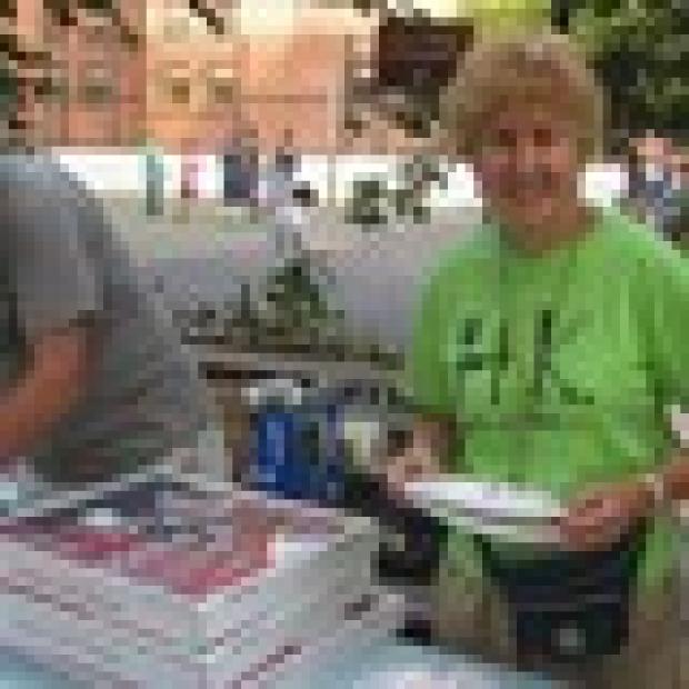 Adrienne Greenstein, 80, from the West 47th-48th Street Block Association, serves pizza to her fellow Midtown North-ers.