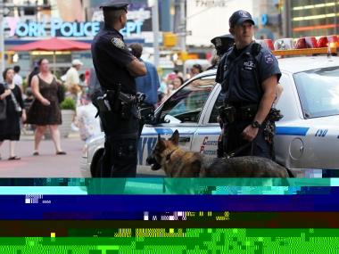 NYPD Detective Bonomo (R) and police canine Hunter keep watch in Times Square June 21, 2010 in New York City. Accused Times Square bomber Faisal Shahzad pleaded guilty on June 21 to all terror and weapons charges.