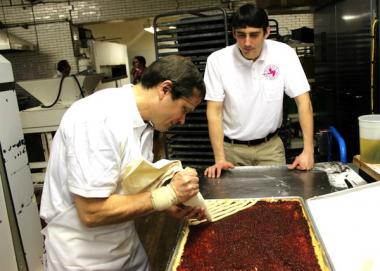  Congressman Mike Quigley helps decorate a raspberry linzer tart with Luke Karl, Norm Dinkel's son-in-law.  
