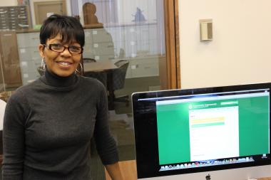  Rosalind Moore, program manager for the Teamwork Englewood Technology Center, stands in front of a donated computer it received from electronic retailer Best Buy. 
