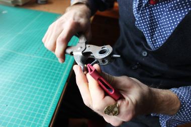  Nathan Minnehan works with a leather iPhone case in his Rogers Park apartment he lofted into three sections. 
