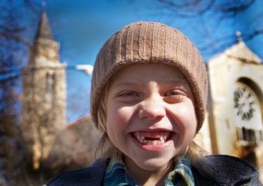  Urban Prairie first-grader Charlie Goodship stands in front of Our Lady of Pompeii Church. Urban Prairie will take over an unused school building that belongs to the church and plans to move in by September. 
