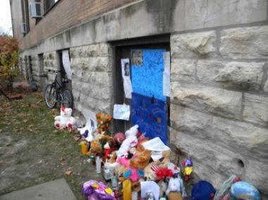  A shrine for a murder victim is filled with stuffed animals and posters.
 