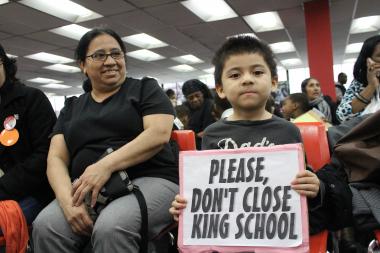  A boy holds a sign at a King Elementary school closure meeting on April 11. On Sunday, Hearing Officer Bernetta Bush recommended the school be kept open. 
