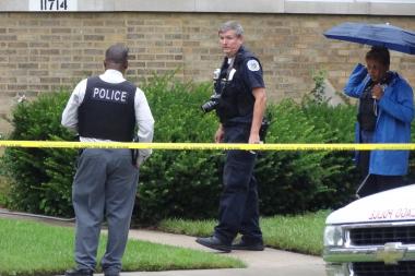  Investigators work the scene of a homicide on the side of a house at 117th and Hale. 
