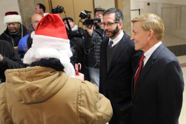  Aldermen John Arena and Bob Fioretti (r.) receive candy canes from City Hall protesters Monday. 
